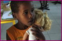 Peit garçon avec une poupée